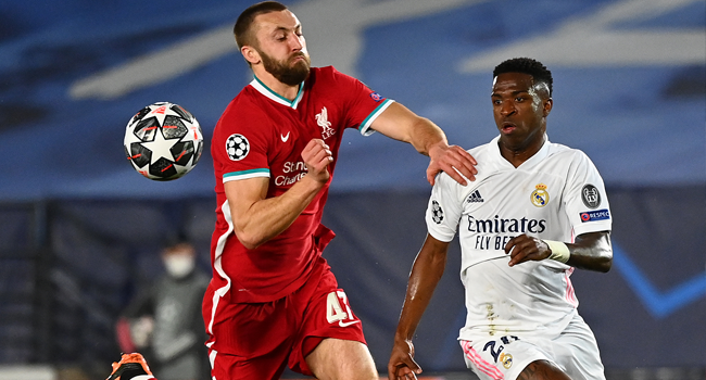 Liverpool's English defender Nathaniel Phillips challenges Real Madrid's Brazilian forward Vinicius Junior (R) during the UEFA Champions League first leg quarter-final football match between Real Madrid and Liverpool at the Alfredo di Stefano stadium in Valdebebas in the outskirts of Madrid on April 6, 2021.  GABRIEL BOUYS / AFP