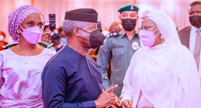 Vice President Yemi Osinbajo converses with First Lady Aisha Buhari during the launch ceremony of a book about the latter on April 8, 2021.